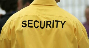 Back view of a security guard in a yellow uniform providing event security in Vancouver.