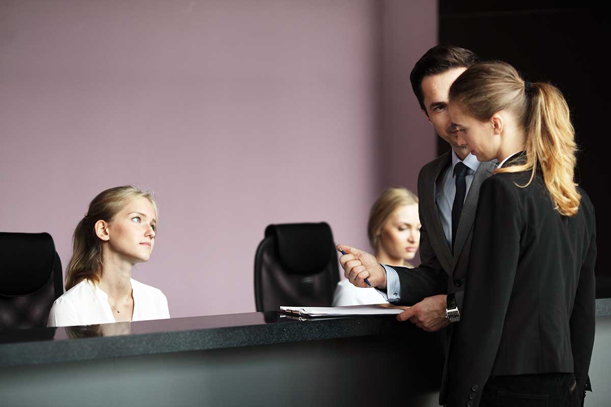 Professional concierge team at a front desk assisting clients in a corporate environment in Vancouver.