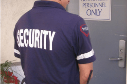 Security guard standing in front of an 'Authorized Personnel Only' door, ensuring restricted access in Vancouver.