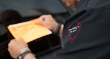 BestWORLD security guard issuing a parking notice on a vehicle in Vancouver.