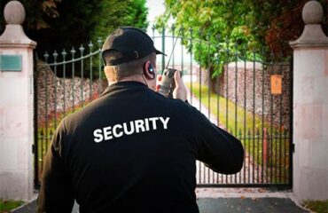 Residential security guard monitoring a gated property in Vancouver with a two-way radio.