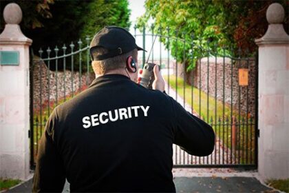 Residential security guard monitoring a gated property in Vancouver with a two-way radio.