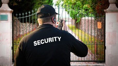 Residential security guard monitoring a gated property in Vancouver with a two-way radio.