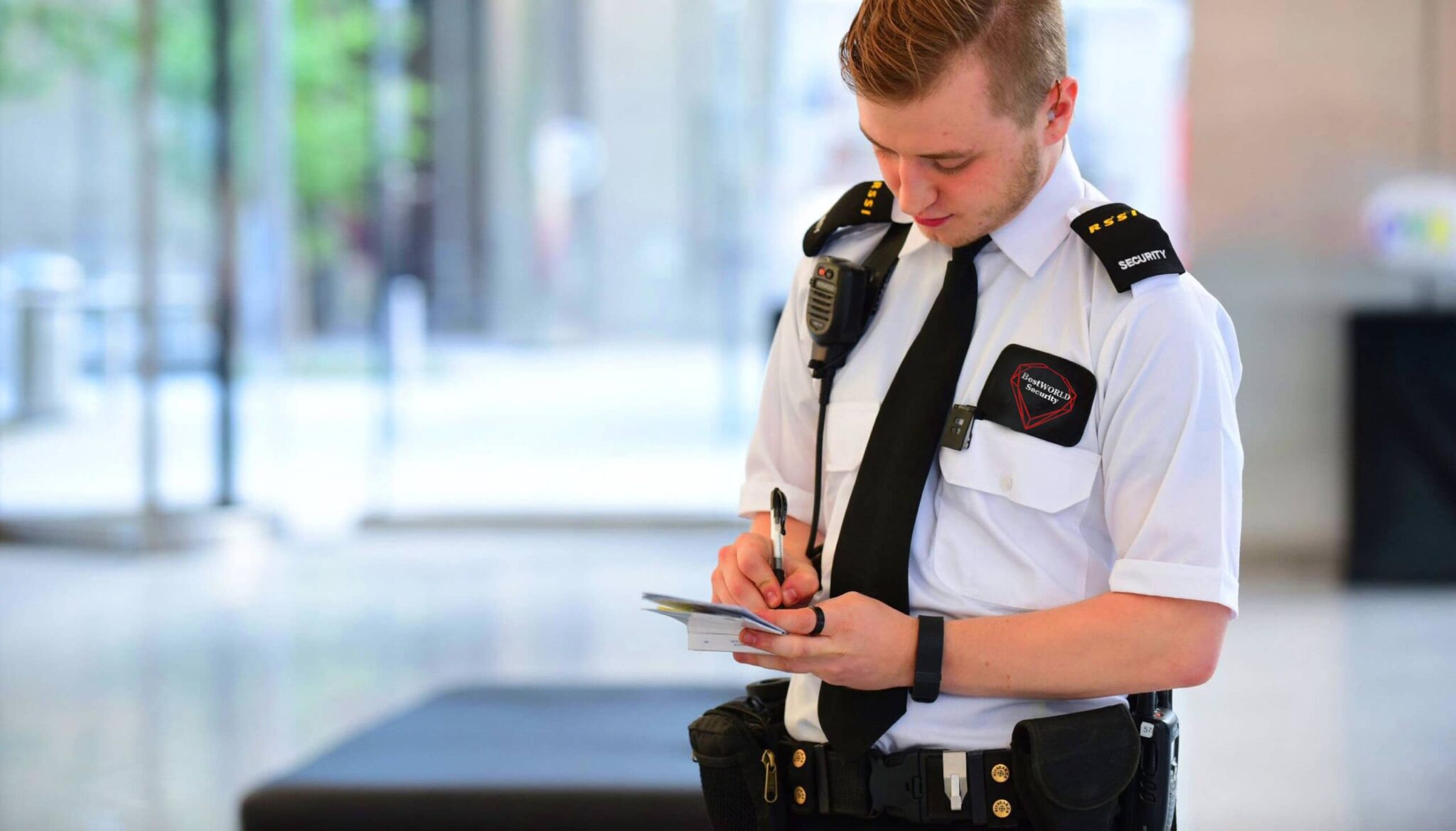 BestWORLD security guard in uniform writing a report inside a commercial building in Vancouver. Professional Security Guards for Commercial Spaces in Vancouver